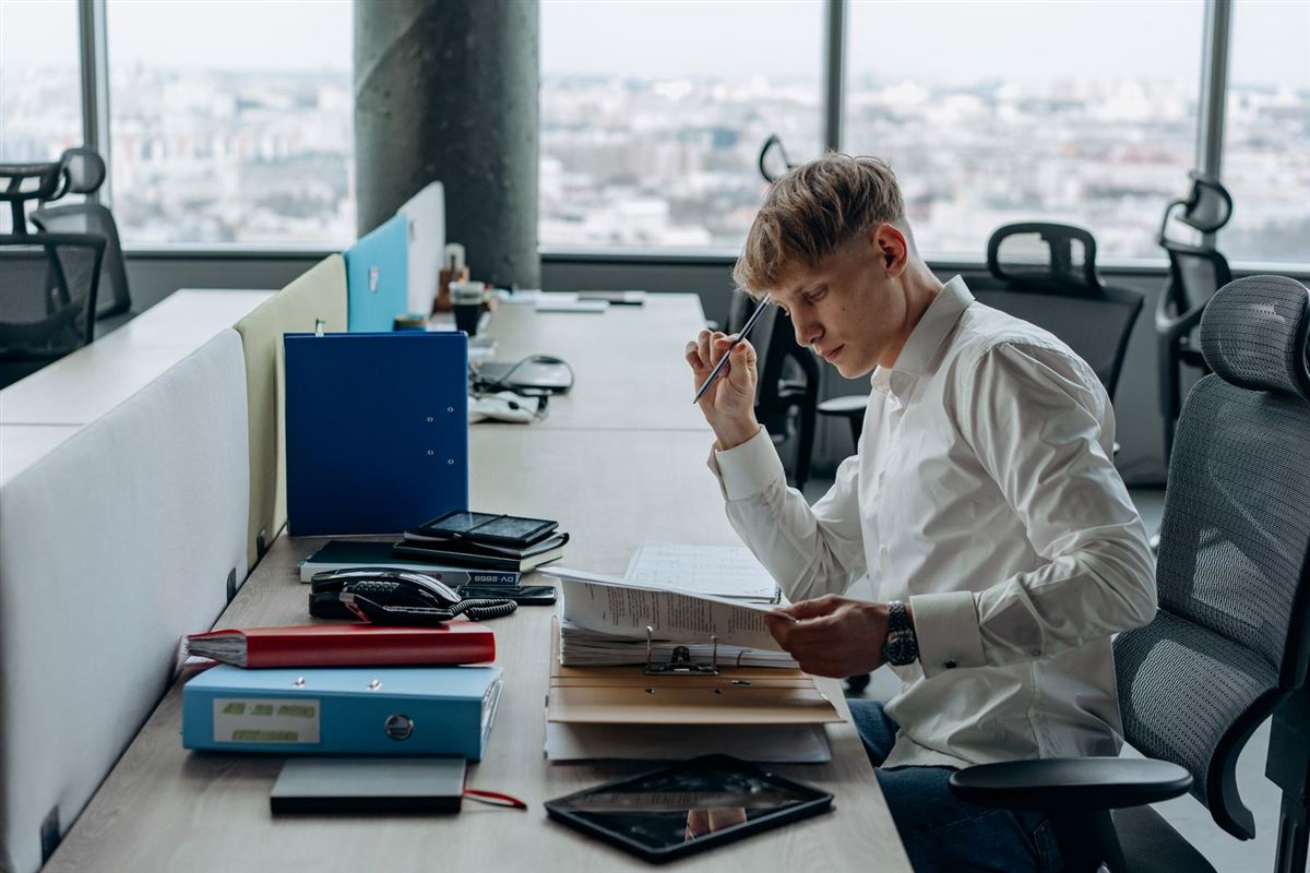 Un homme examine un dossier à son bureau