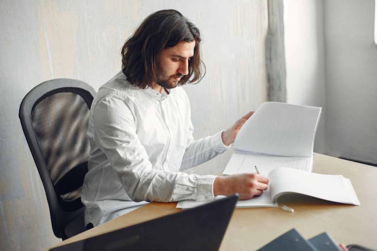 Un homme remplit des documents à son bureau